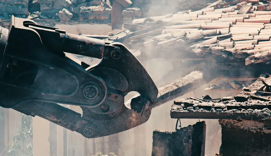 Long-reach machine bringing down a structure on a San Antonio job site