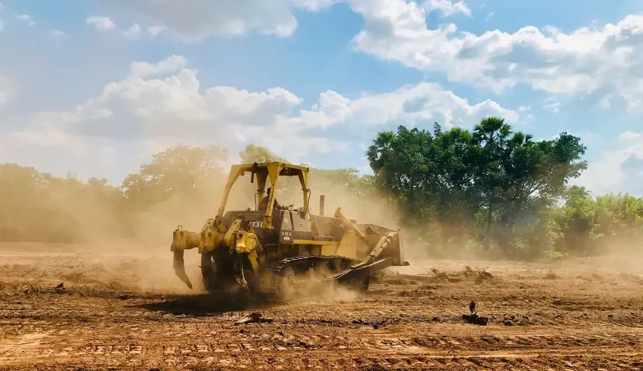 Dozer clearing brush and ground on an open lot